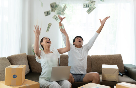 Young couple working with their small business at home office togetherの写真素材