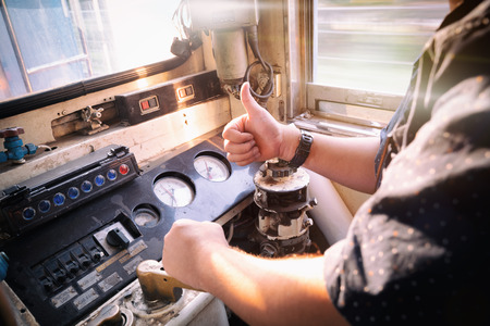 Train driver checking engine of train and gesture the hand to already from the station