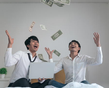 Business male couple success own their business with holding money and throwing up to the sky.の写真素材