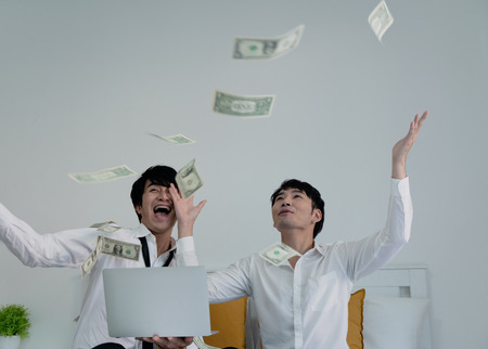Business male couple success own their business with holding money and throwing up to the sky.の写真素材