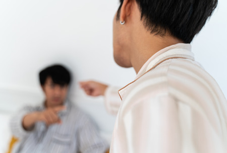 Gay couple having argument and do not take care each other in bedroom at home. Homo sexual love concept.の写真素材