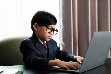 Little boy in Busines suit working with notebook in office.の写真素材