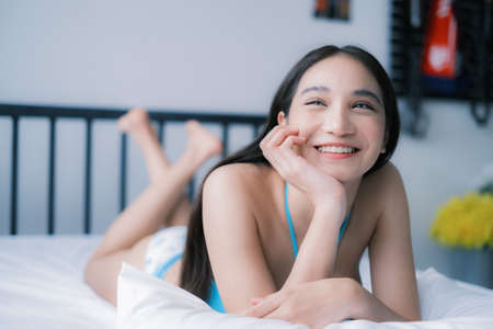 Asian woman with bikini posing in a home environmentの写真素材