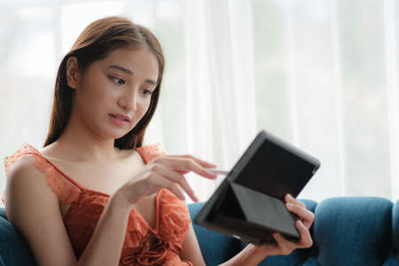 Asian woman with bikini using tablet in a home environment