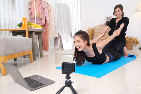 Young couple asian women spendong times at home to excerise and play with her dog.