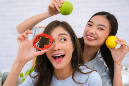 Young Asian couple women enjoy to cooking salad at home.の写真素材