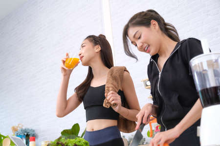 Young couple women with sports clothing enjoy to make saladの写真素材