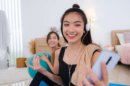 Young couple asian women spendong times at home to excerise and play with her dog.の写真素材