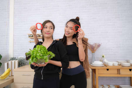 Young couple women with sports clothing enjoy to make saladの写真素材