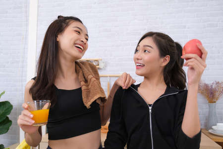 Young couple women with sports clothing enjoy to make saladの写真素材