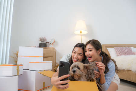 Couple Asian women be happy to in new house with her dogの写真素材