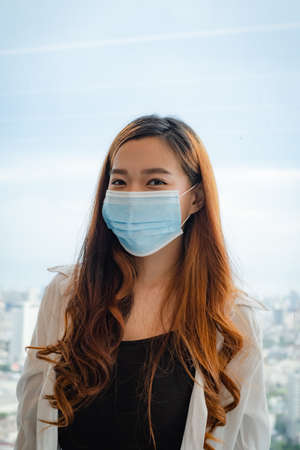 Asian woman smile behind the medical face mask.の写真素材