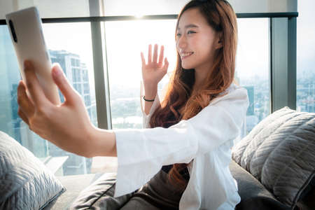 Young Asian woman use mobile to video call and talking at home.
