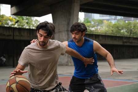 Two caucasian men pratice baskegball in court at urban street.
