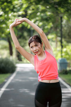 Asian woman doing exercise and relax in pubic park.の写真素材