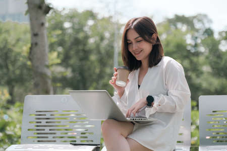 Young Asian woman working with notebook in park