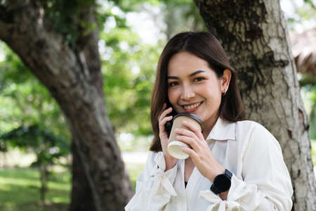Young Asian woman working with notebook in park