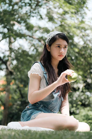 Young Asian woman relaxing in parkの写真素材