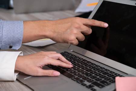 Close up of finger's business hand point to laptop.の写真素材
