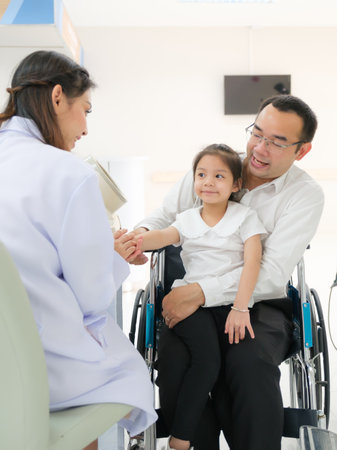 Young female doctor health examination to old female patient and her family sitting on wheelchair.の写真素材