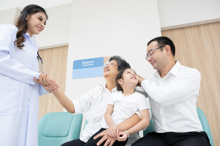 Young female doctor health examination to old female patient and her family sitting on wheelchair.の写真素材