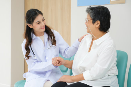 Young female doctor health examination to old female patient and her family sitting on wheelchair.の写真素材