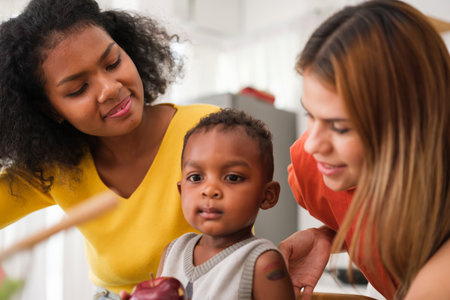 Lesbian couple with their little baby in kitchen