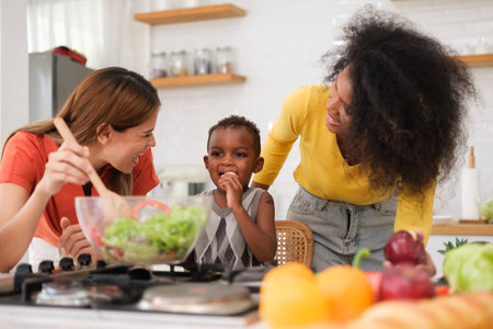 Lesbian couple with their little baby in kitchenの写真素材