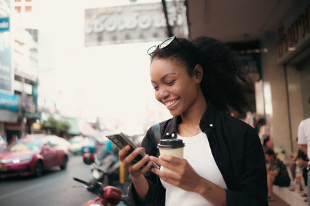 Asian woman enjoy travel in  downtown district and she taking a photo and using mobile live on social media and tasting streetfoods.の写真素材