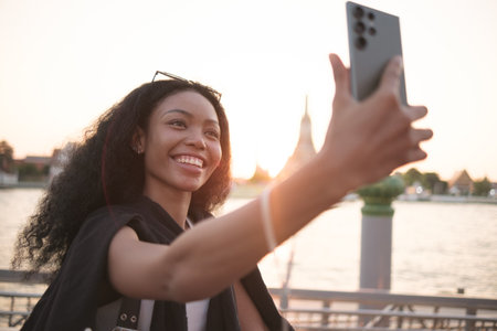 Asian woman enjoy travel in  downtown district and she taking a photo and using mobile live on...