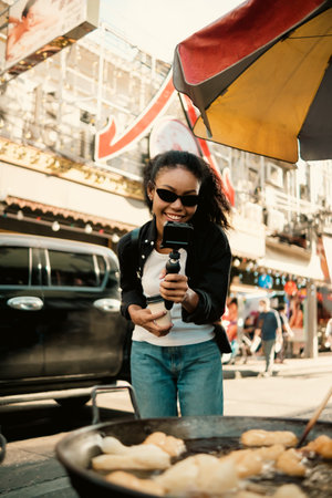Asian woman enjoy travel in  downtown district and she taking a photo and using mobile live on...