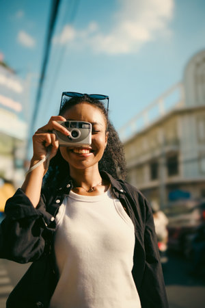 Asian woman enjoy travel in  downtown district and she taking a photo and using mobile live on social media and tasting streetfoods.の写真素材
