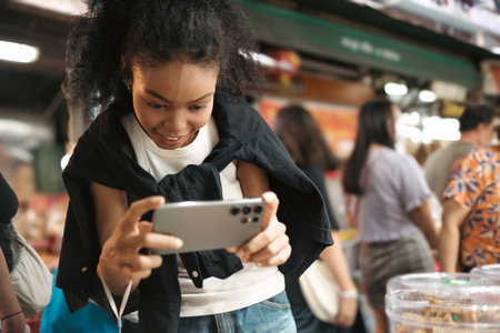 Asian woman enjoy travel in  downtown district and she taking a photo and using mobile live on...