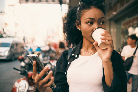 Asian woman enjoy travel in  downtown district and she taking a photo and using mobile live on social media and tasting streetfoods.の写真素材