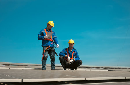 Engineers or workers install and inspect solar cell on the roof of the factory.の写真素材