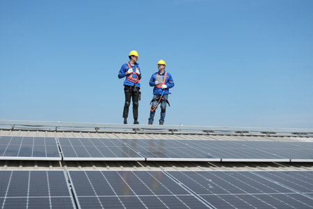 Engineers or workers install and inspect solar cell on the roof of the factory.