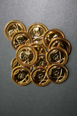A load of golden coins with pirates mark printed on themの写真素材