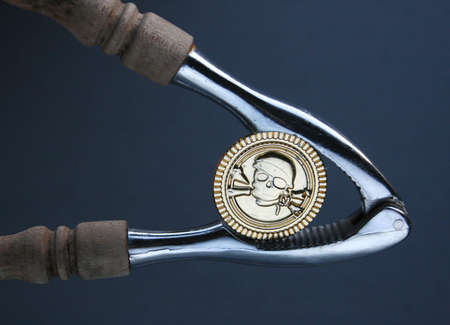financial squeeze, money in a wrench, pirate coin in a nut cracker