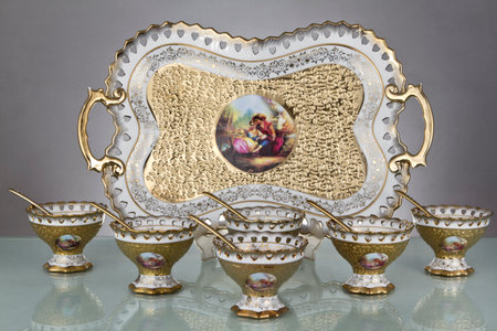 Antique porcelain tableware , Ceramic tableware , Antique gold pot , Vintage porcelain plate on a gray background with a reflectionの写真素材