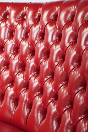 red leather upholstery sofa texture background. closeup of luxury sofa with buttonsの写真素材