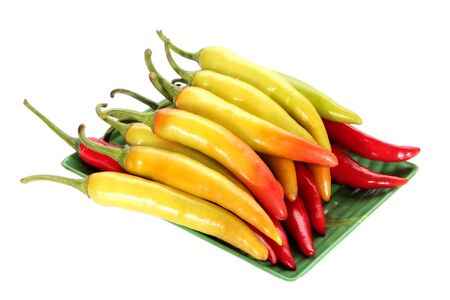 yellow chili pepper on green dishの写真素材