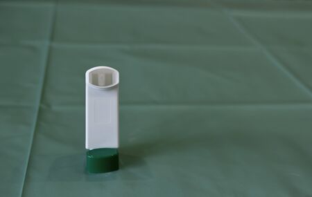Asthma spray colored medicinal inhaler with the cap on the medical oilcloth.の写真素材