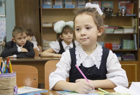 Russia, Krasnoyarsk region, Igarka, December 2015: back to school. the girl sits at her Desk and attentively listens to the teacherのeditorial素材