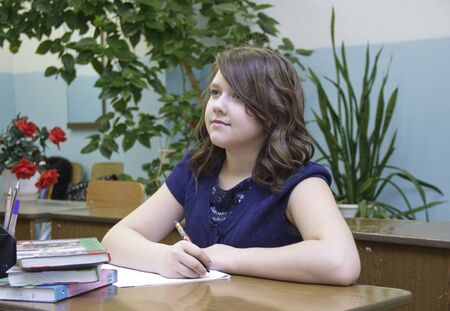 Russia, Krasnoyarsk region, Igarka, December 2015: back to school. the girl sits at her Desk and attentively listens to the teacherのeditorial素材