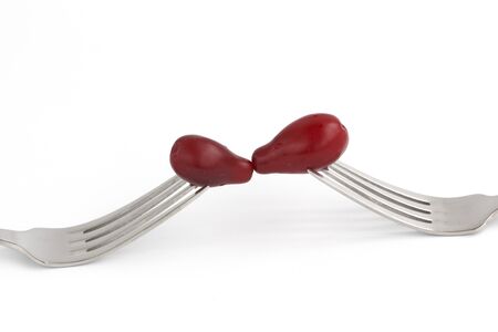 Cornelian Cherry Cornus mas on fork isolated on white background. berry kiss.