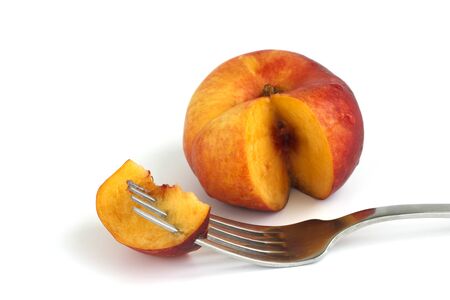 sliced peach on fork on isolated white background.の写真素材
