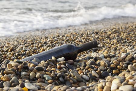 bottle of wine in the sea waves. Romantic day with glasses of red wine sitting on the beach of tropical island at the summer sunny day. Waves and sea on the background. Wedding concept...の写真素材