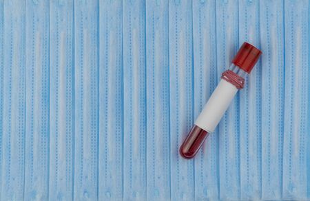COVID corona virus disease 2019. medical protective mask and blood test tube. The concept of...