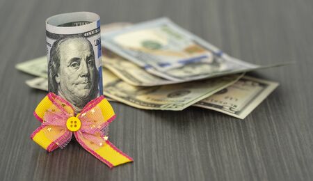 dollar tied with a festive bow. American currency, paper currency notes. the concept of celebrating the birthday of the dollar on April 01の写真素材