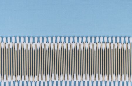 Flat lay composition with cotton swabs on blue background. natural cotton sticks made from cotton...